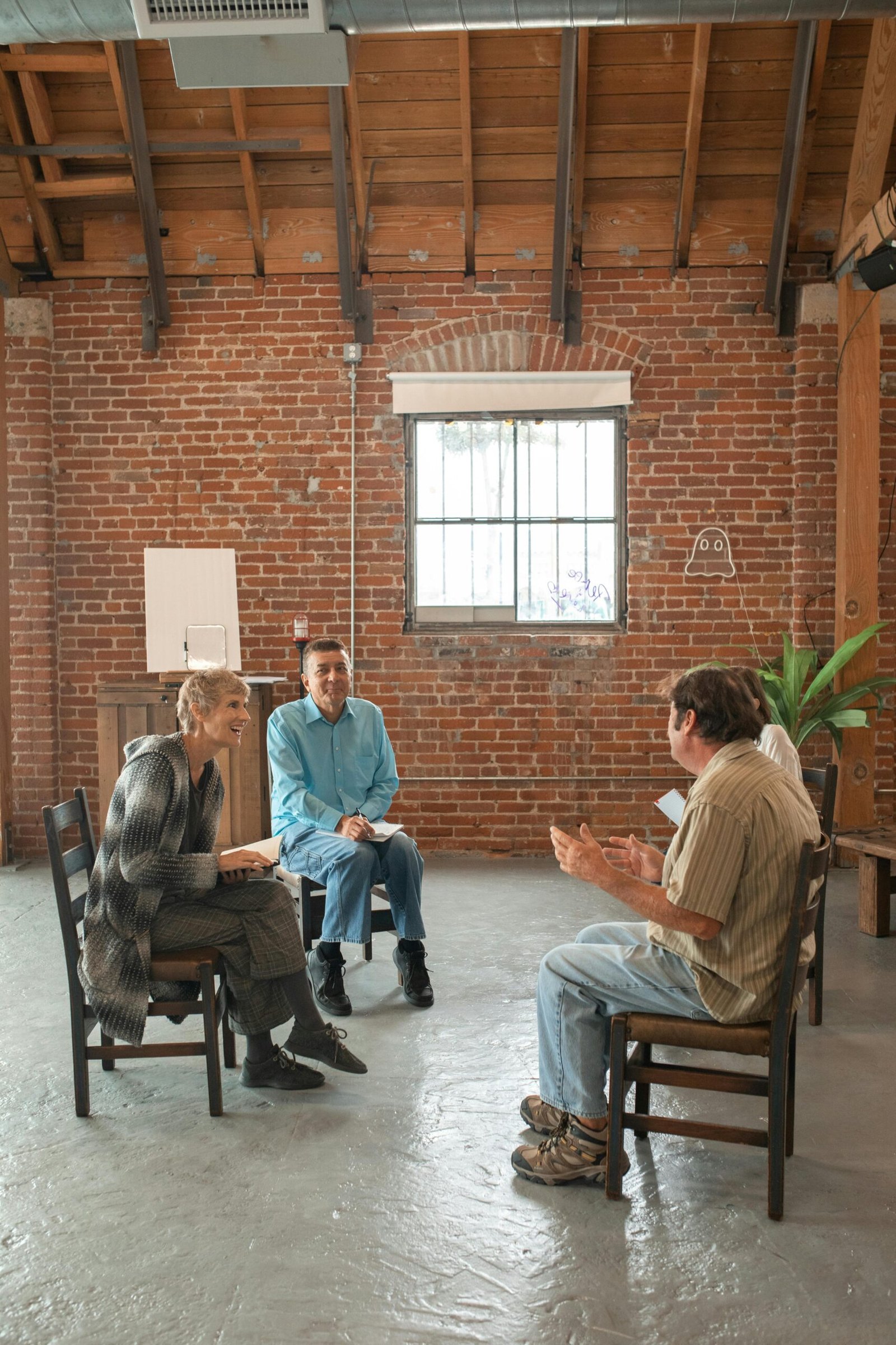 Adults in a cozy setting having a group discussion with a leader guiding the session.